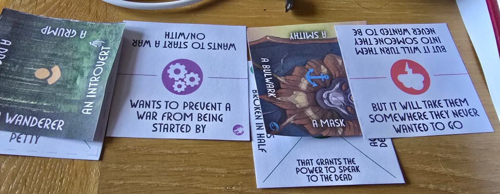 Cards showing "a petty wanderer wants to prevent a war from being started by a mask that grants the power to speak to the dead but it will take them somewhere they never wanted to go”